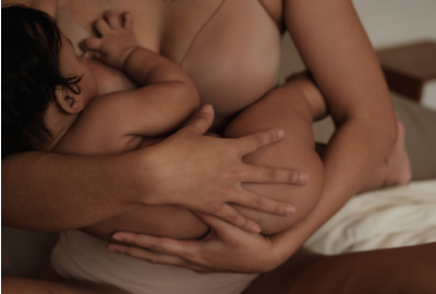 Mother lovingly breastfeeding her newborn baby